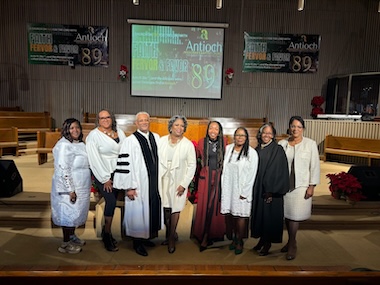 Group of people standing together in a church setting with festive decorations