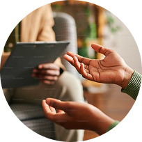 Close-up of a person gesturing during a counseling session with a therapist holding a clipboard