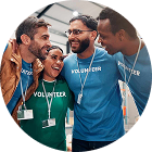 Group of diverse volunteers smiling and wearing lanyards in a community center