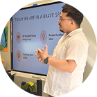 Man giving a presentation on bravery principles at a smart display screen in a casual setting