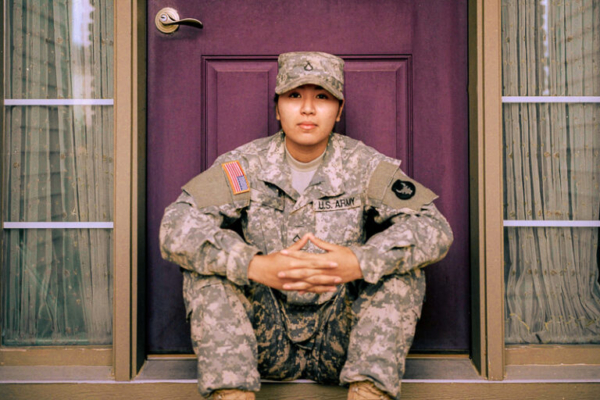 Soldier in uniform sitting on steps in front of a door