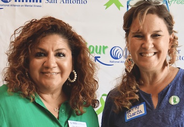 Two women smiling at a NAMI San Antonio mental health event backdrop